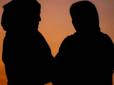 Silhouetted figure doing a standing stretch against window